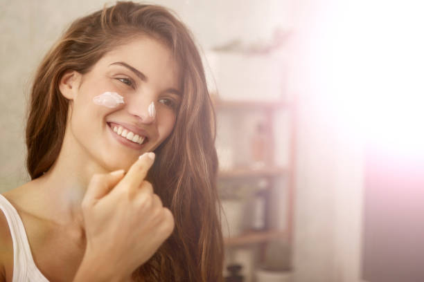 girl applying moisturizer on her face skin