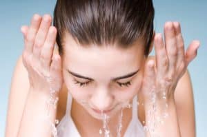Girl splashing water on her face.